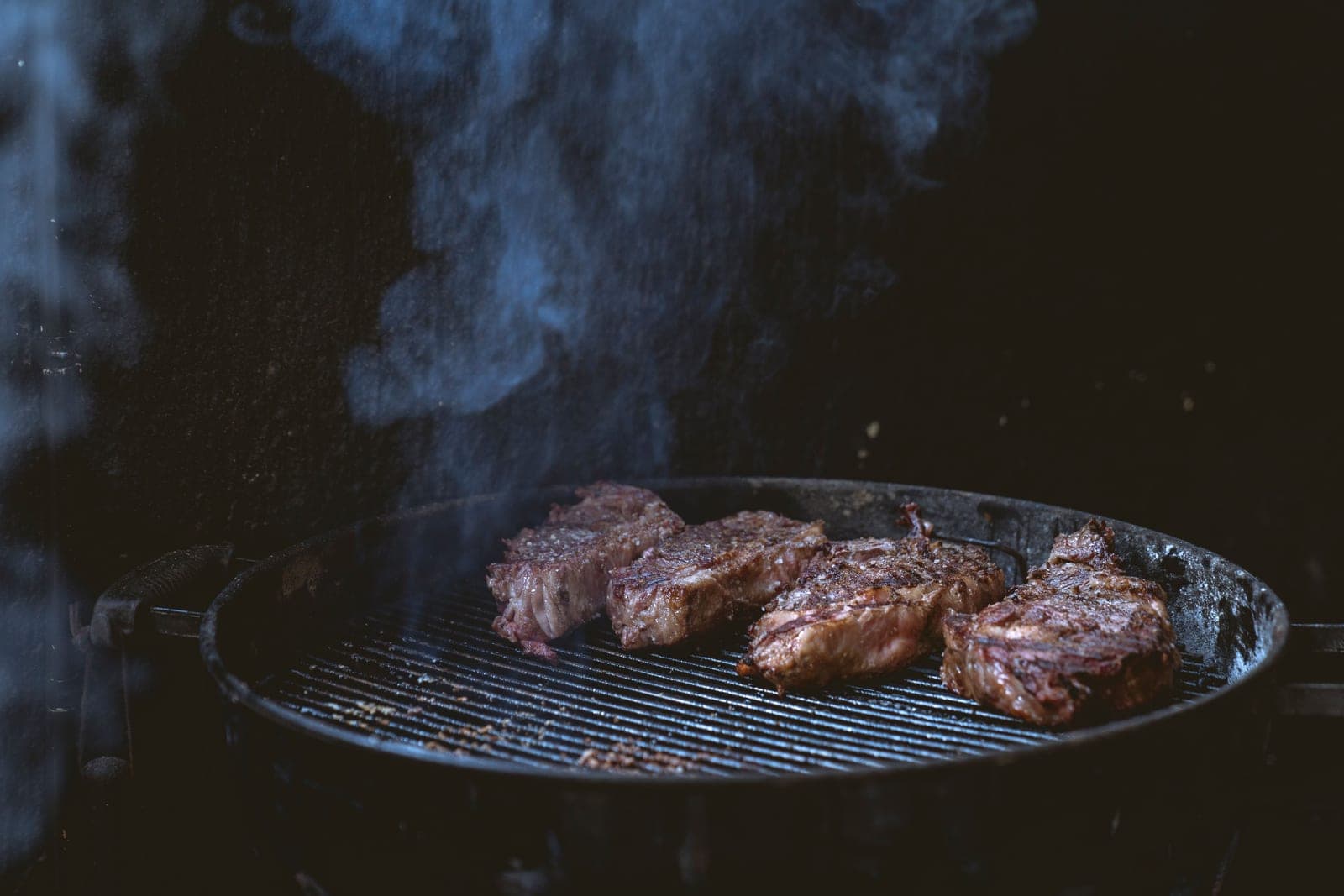A steak searing over flames on a grill
