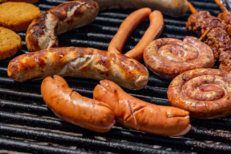 Sausages and meats grilling on an outdoor barbecue