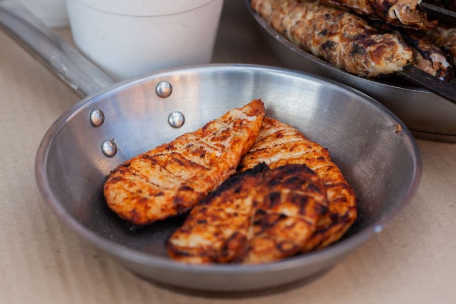 Seasoned chicken breasts grilling on a barbecue