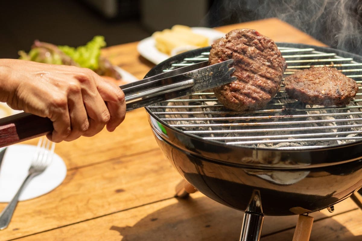 Stainless steel grilling tools on a dark background