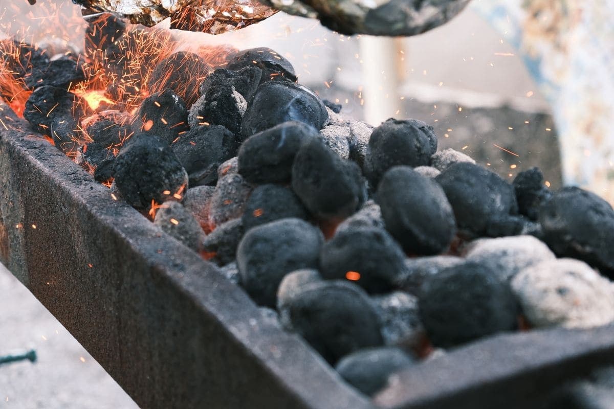 Sparks flying from burning charcoal in a barbecue grill