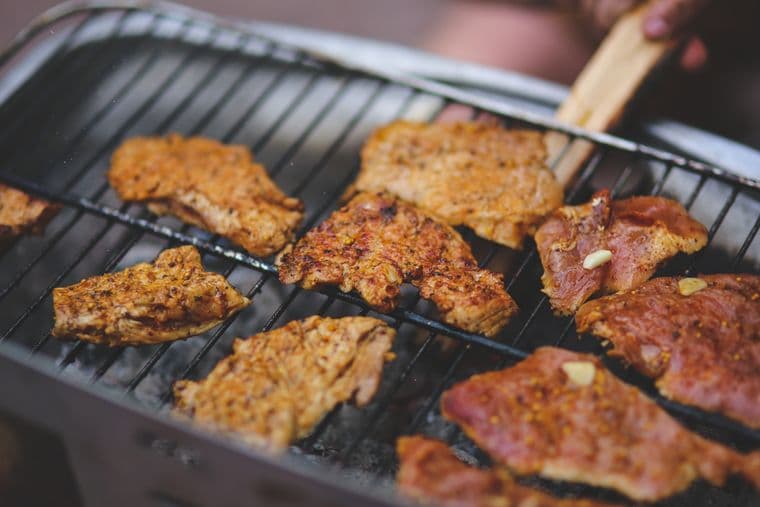 Seasoned pork chops grilling on an outdoor barbecue