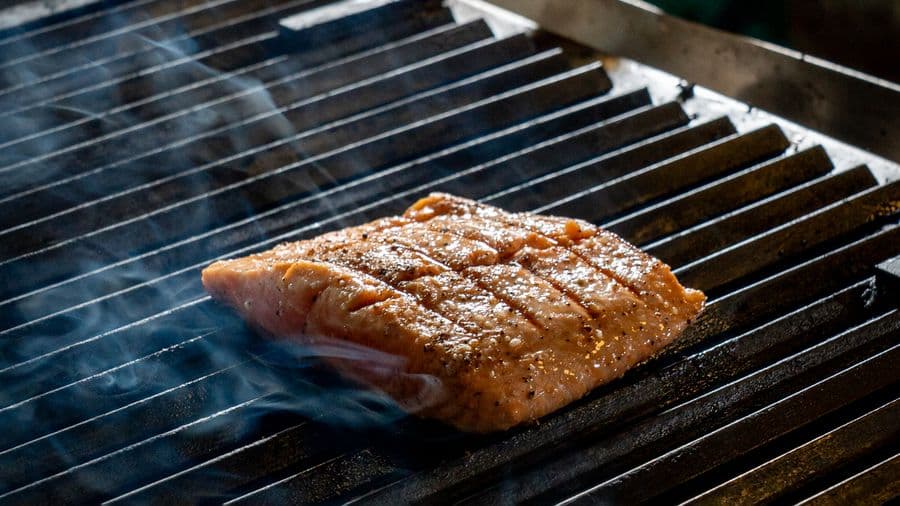 A salmon fillet cooking on an outdoor grill