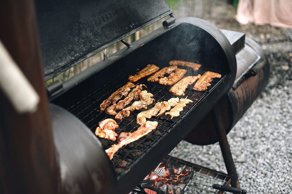 Smoke rising from ribs in a barbecue smoker