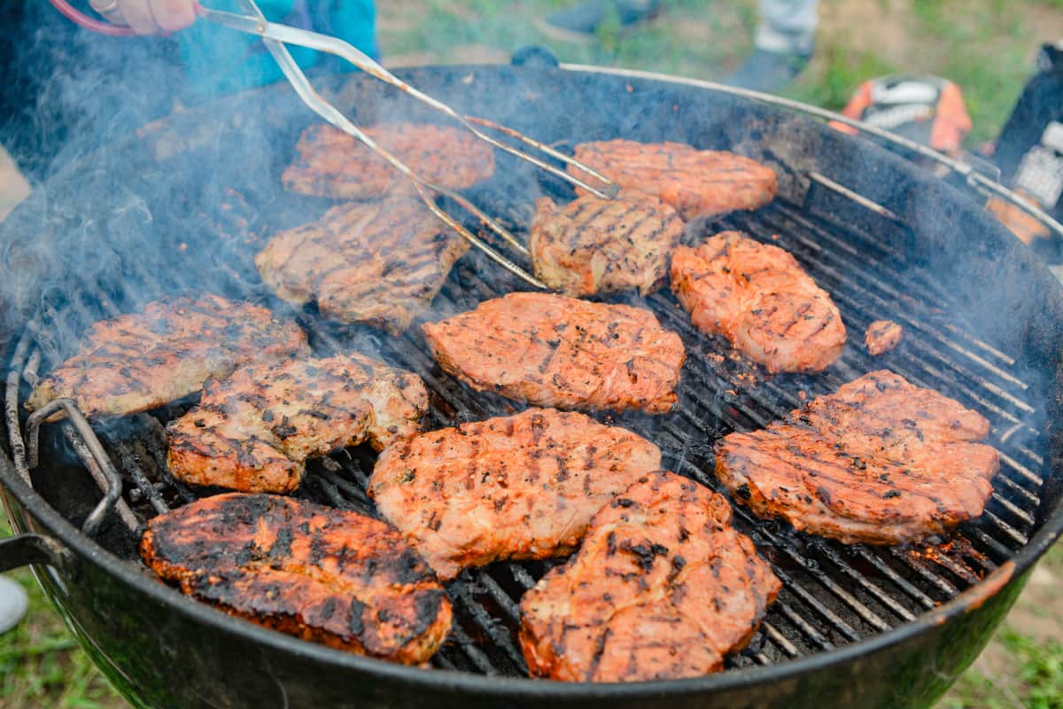 A meat thermometer checking food on a grill