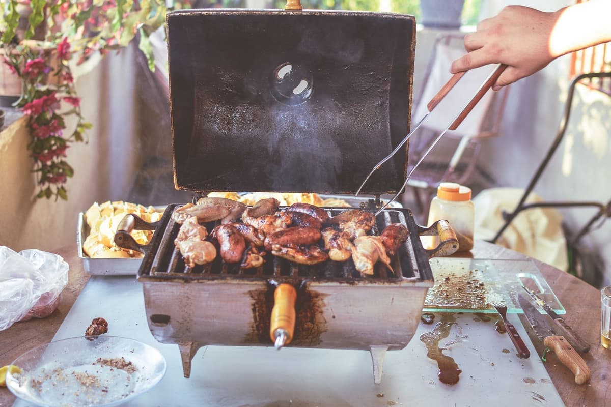 Meat and vegetables cooking across a barbecue grate